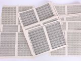 plusieurs feuilles de papier portant des timbres, posées sur une surface blanche