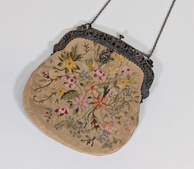 un petit sac à main orné de fleurs, suspendu à une chaîne