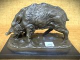 statue en bronze représentant un sanglier, posée sur un socle sur lequel est fixée une étiquette
