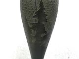 a black vase that is sitting on a white table