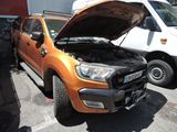 un camion orange dont le capot est ouvert, garé sur un parking