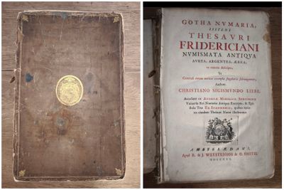 an old book sitting on top of a wooden table next to another book
