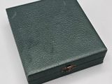 a green leather box with a gold star on the lid