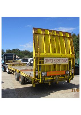 un camion garé sur un parking, avec un panneau à l'arrière