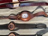 several watches are lined up in a case on a table