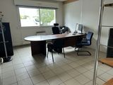 a desk and chair in a room with a large window