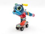 brightly colored figurine of a dog on a skateboard on a white background