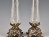 pair of silver and glass vases on pedestals on grey background