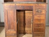 a wooden desk with drawers and a mirror on it