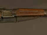 un vieux fusil avec un canon en bois et une poignée en métal