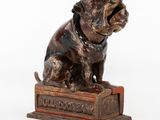statue d'un chien assis sur une caisse, avec un collier autour du cou
