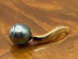 une perle noire posée sur une table en bois, à côté d'une banane
