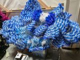 un dragon bleu et blanc fait de fil à tricoter, posé sur une table