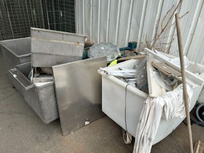 un tas d'ordures devant un immeuble, à côté d'une poubelle