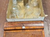a wooden box with a lot of glass items in it
