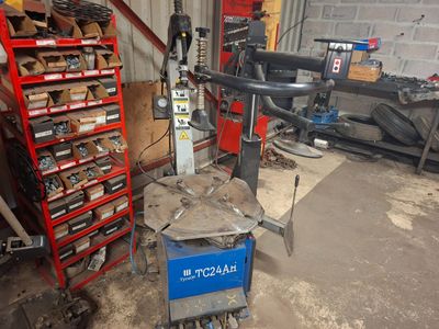 a machine that is sitting in a garage next to a shelf of tools