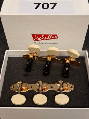 a white box with four gold tone guitar heads in it
