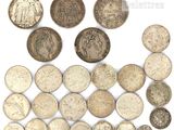 an assortment of old coins on a white surface
