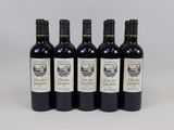 four bottles of wine are lined up on a white surface