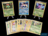 Plusieurs cartes Pokémon sont disposées sur une table avec un fond noir.