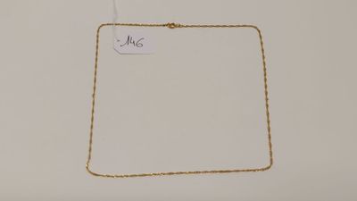 gros plan sur un collier en or portant une étiquette