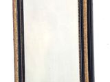 un miroir noir et doré accroché au mur