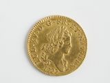 une vieille pièce d'or posée sur une surface blanche