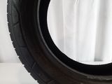 tire on a white surface with a white curtain in the background