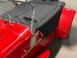 a red car with a black top parked in a garage