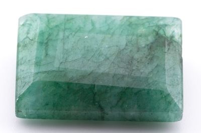 gros plan d'une pierre d'émeraude verte sur une surface blanche