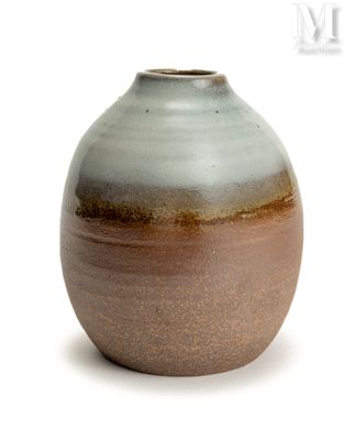 un vase brun et blanc posé sur une surface blanche
