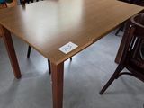 une table et des chaises dans une pièce où il y a un tableau accroché au mur