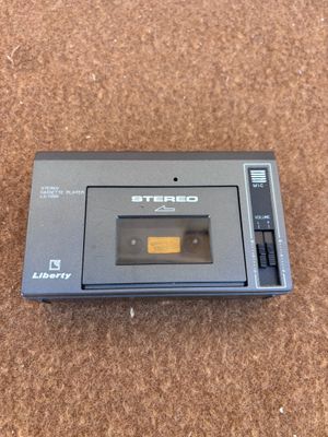 un lecteur de cassettes posé sur un sol recouvert de moquette
