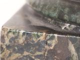 a close up of a statue of a bird on a marble base