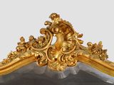 a mirror with a gold frame with a woman on it