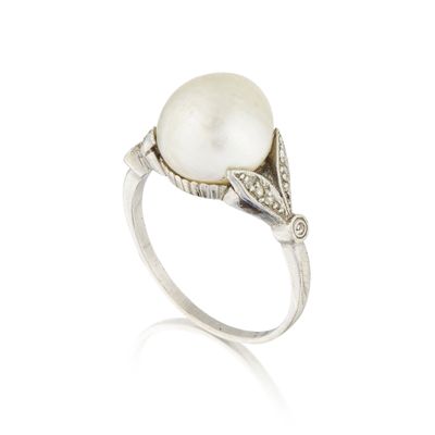 gros plan d'une bague en perles et diamants sur fond blanc