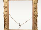 a picture of a gold frame with a necklace on it