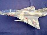 a model of a fighter jet sitting on a blue surface