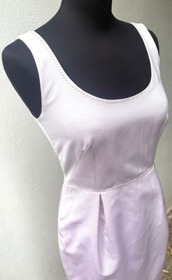 une robe blanche sur un mannequin posé sur un pied de mannequin