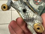 a small figurine of a frog that is in someone ' s hand