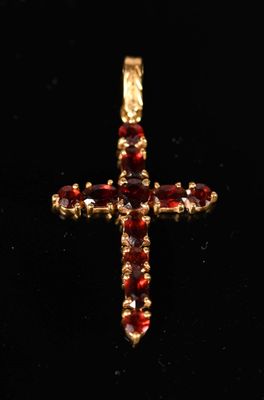 une image représentant une croix en or sertie de grenats sur fond noir