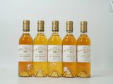 quatre bouteilles de vin sont alignées sur une surface blanche