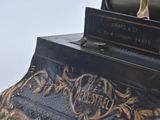 a black and gold clock that is on a table