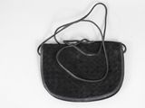 sac à main en cuir noir sur fond blanc, avec une bandoulière noire