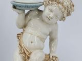 a statue of a boy with a bowl on his head