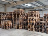 un gros tas de palettes dans un entrepôt