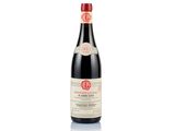 a bottle of red wine sitting on top of a white table