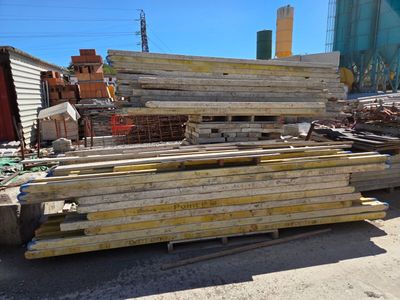 a pile of wood sitting on the ground in front of a building