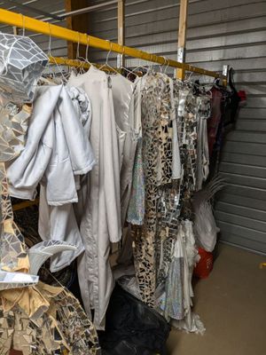 beaucoup de vêtements suspendus à une étagère dans une pièce