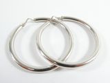 une paire de boucles d'oreilles créoles en argent sur fond blanc